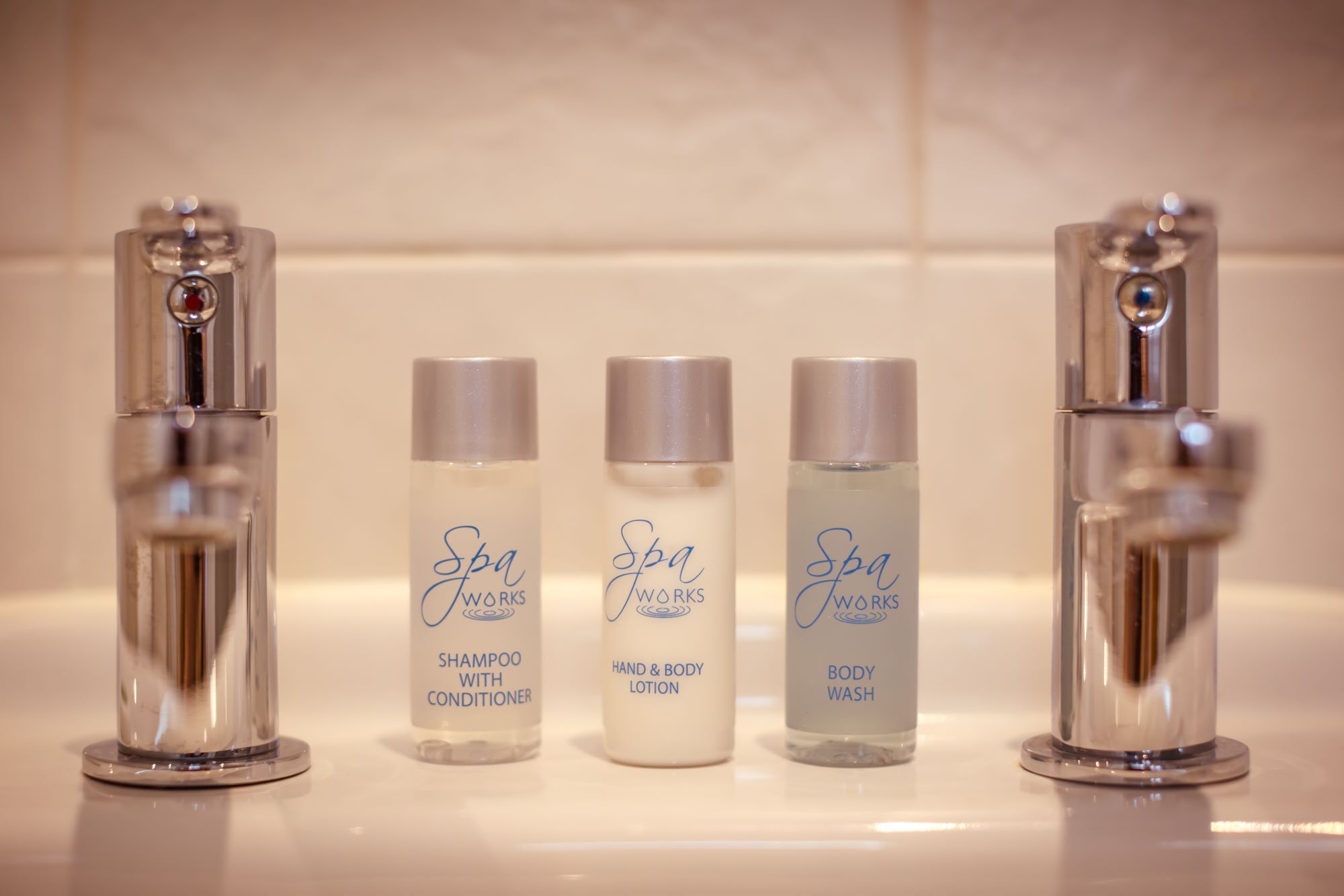 Three bottles of spa products on a bathroom counter.