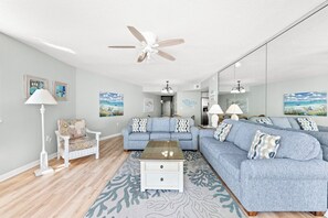 A living room with a ceiling fan, a sofa set, a coffee table, and a floor lamp. - 4-bedroom, 3-bathroom, oceanfront unit, sleeps 10 | Ocean Bay Club - 401 (North Myrtle Beach)