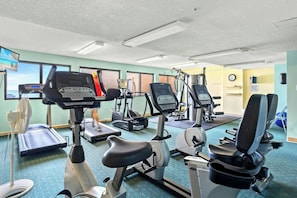 A gym with various exercise equipment including treadmills, stationary bikes, and weight machines. - 4-bedroom, 3-bathroom, oceanfront unit, sleeps 10 | Ocean Bay Club - 401 (North Myrtle Beach)