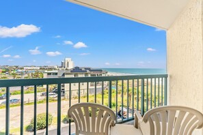 A balcony with a view of the beach and cityscape, featuring a railing and two chairs. - 4-bedroom, 3-bathroom, oceanfront unit, sleeps 10 | Ocean Bay Club - 401 (North Myrtle Beach)