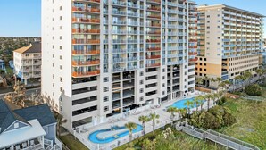 A multi-story hotel with balconies, a swimming pool, and a parking area. - Penthouse, 3-bedroom, 3-bathrooms, updated flooring and countertops  | South Shore Villas - PH05 (North Myrtle Beach)