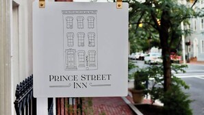 Une enseigne pour le Prince Street Inn, avec un simple dessin linéaire représentant un bâtiment.