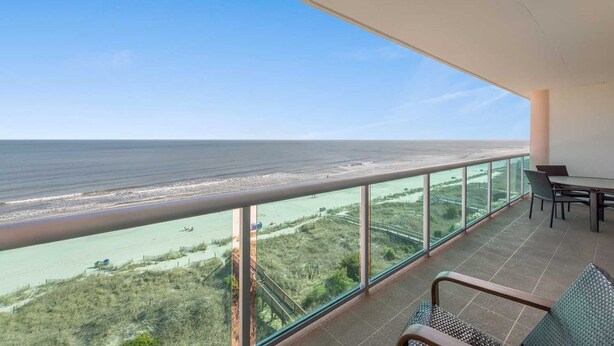 A balcony with a view of the ocean and a distant shoreline. - 3-bedroom oceanfront condo with lots of updates | Crescent Keyes - 705 (North Myrtle Beach)