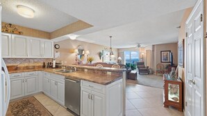 A spacious kitchen with white cabinets, a granite countertop, and a built-in dishwasher. - First Floor Corner Unit, 3-bedroom/3-bath condo | Beach Club - 1E (North Myrtle Beach)