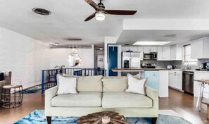 A modern living room with a sofa, a coffee table, and a ceiling fan. - Manatee Pocket! Whole House & Backyard to Yourself (Stuart)