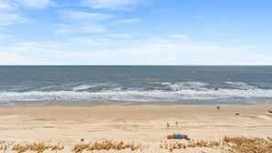 Une plage avec un ciel dégagé, un rivage sablonneux et l’océan.