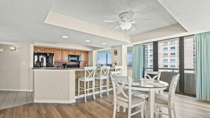 Une cuisine moderne avec des meubles en bois, un réfrigérateur en acier inoxydable et un four à micro-ondes.