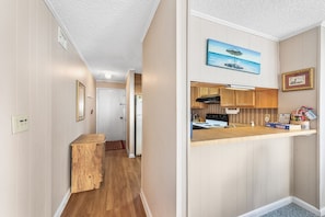 Una cocina compacta con armarios de madera, estufa integrada y una pequeña encimera.
