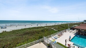 A beach view with a swimming pool and lounge chairs. - Two bedroom, two-bathroom oceanfront condo | Crescent Beach Villas - 201 (North Myrtle Beach)