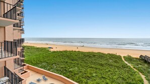 A beachfront hotel with a pool, a beach view, and a grassy area. - 2-bedroom Corner Unit with private balcony | Carolina Reef - 301 (North Myrtle Beach)