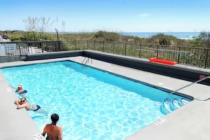 A rectangular swimming pool with a metal ladder, a lifeguard chair, and a sign prohibiting diving. - Sea Lovers Delight! 3-bedroom, 2-bathroom, oceanfront condo | Sea Castle - 7B (North Myrtle Beach)