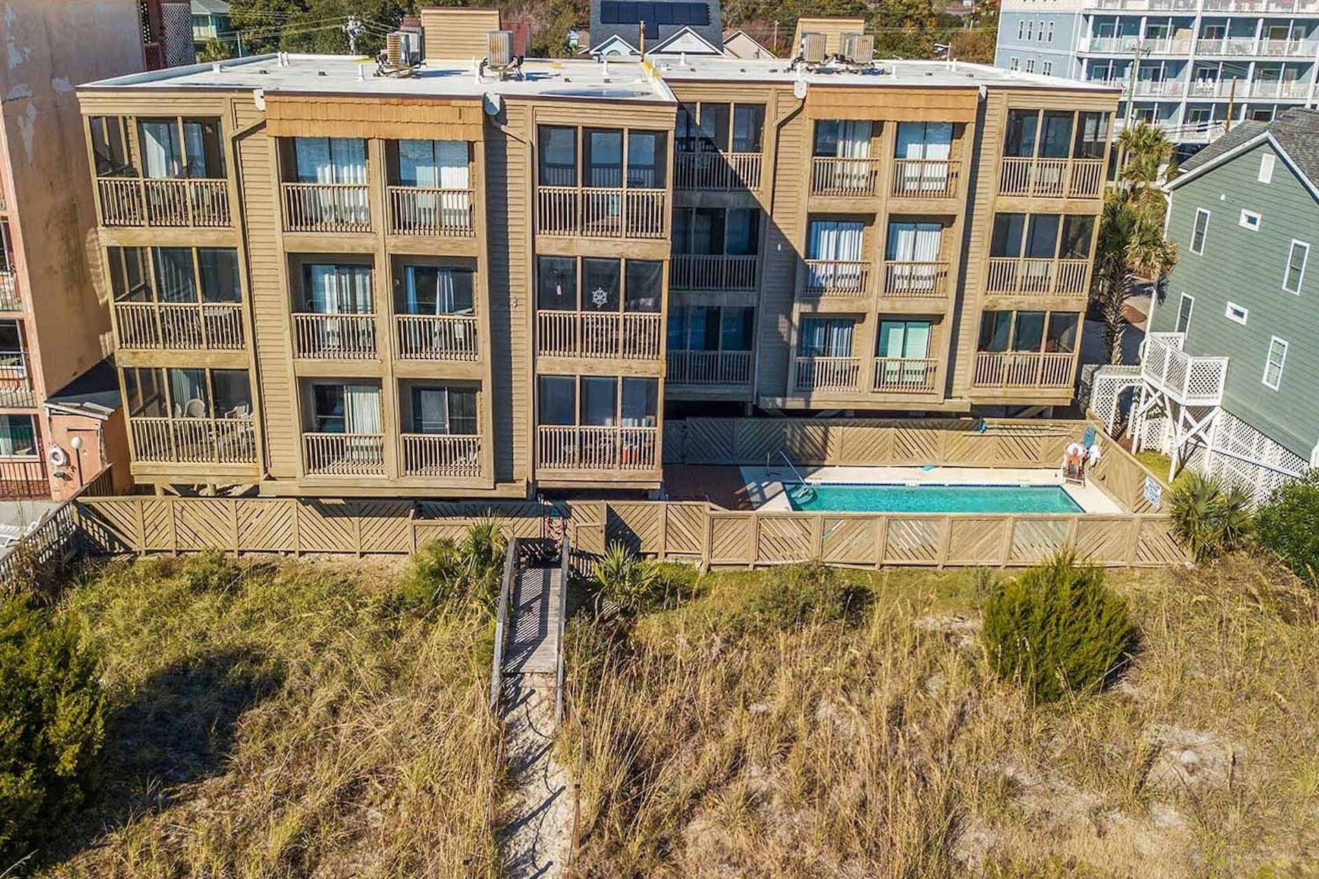 Un edificio de varios pisos con balcones y una piscina.