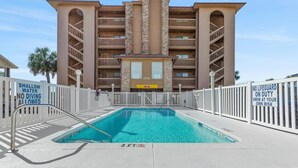 A hotel with a pool, a sign indicating shallow water, and a no diving allowed sign. - Renovated 1-bedroom, 1-bath 3rd floor oceanfront condo | Ocean Inn - 303 (North Myrtle Beach)