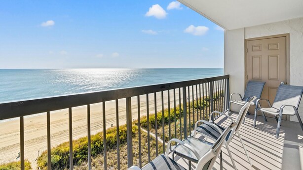 Un balcon avec vue sur la plage et l’océan.
