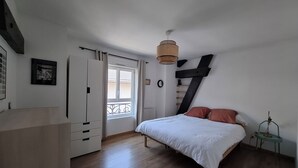 A bedroom with a bed, a wardrobe, a window, and a hanging light fixture. - Quiet, bright apartment, 400 metres from the town center, with parking lot (Aix-les-Bains)