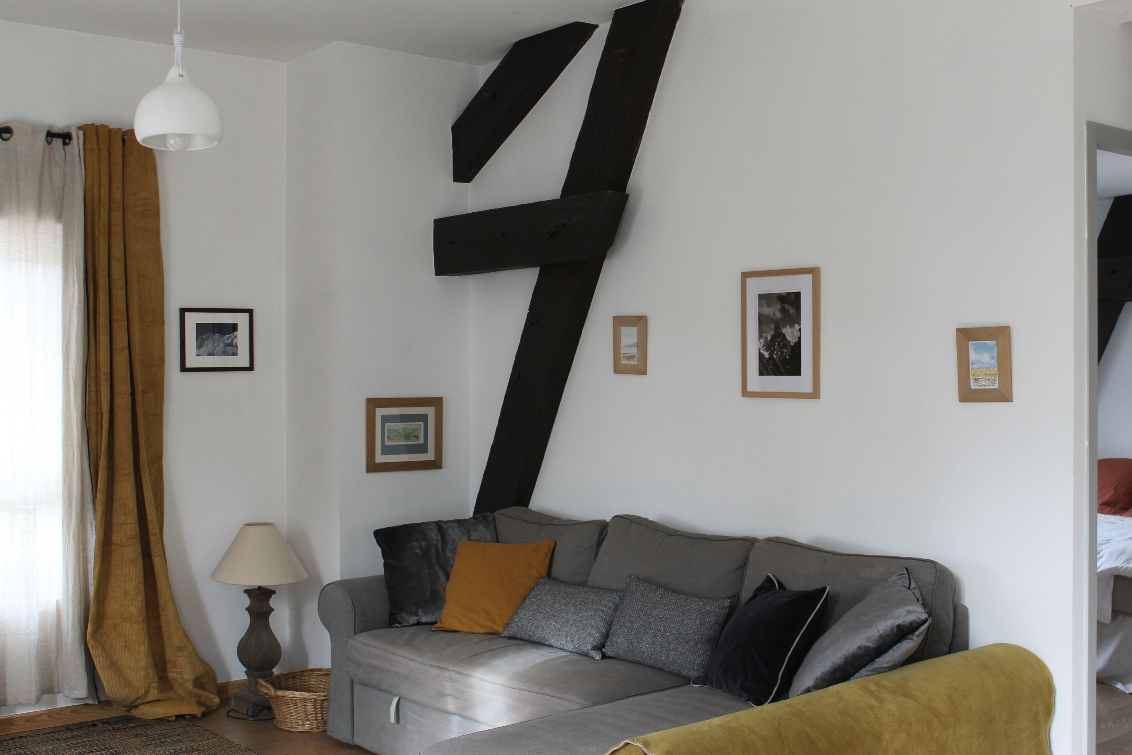 Ett vardagsrum med en soffa, en lampa och en stor, abstrakt skulptur.