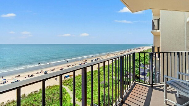 Ein Balkon mit Blick auf Strand und Meer.