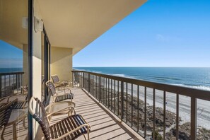 Un balcon avec vue sur la plage et l’océan.