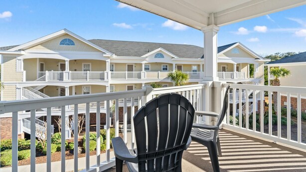 A hotel with a covered balcony, multiple balconies, and a view of other hotel buildings. - Golf Course Views, 2-bed, 2-bath Condo, Barefoot Resort | Ironwood - 834 (North Myrtle Beach)