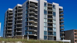 A modern multi-story hotel with balconies, large windows, and a beachside location. - 3-bedroom, 2-bathroom, oceanfront condo, Plenty of updates and upgrades | Sea Castle - 5C (North Myrtle Beach)