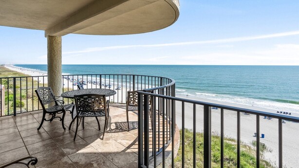 A balcony with a curved railing overlooking a beach. - 3-bedroom, 2-bathroom, oceanfront condo, Plenty of updates and upgrades | Sea Castle - 5C (North Myrtle Beach)