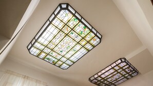 Une pièce dotée d’un plafond en pente et de deux vitraux.