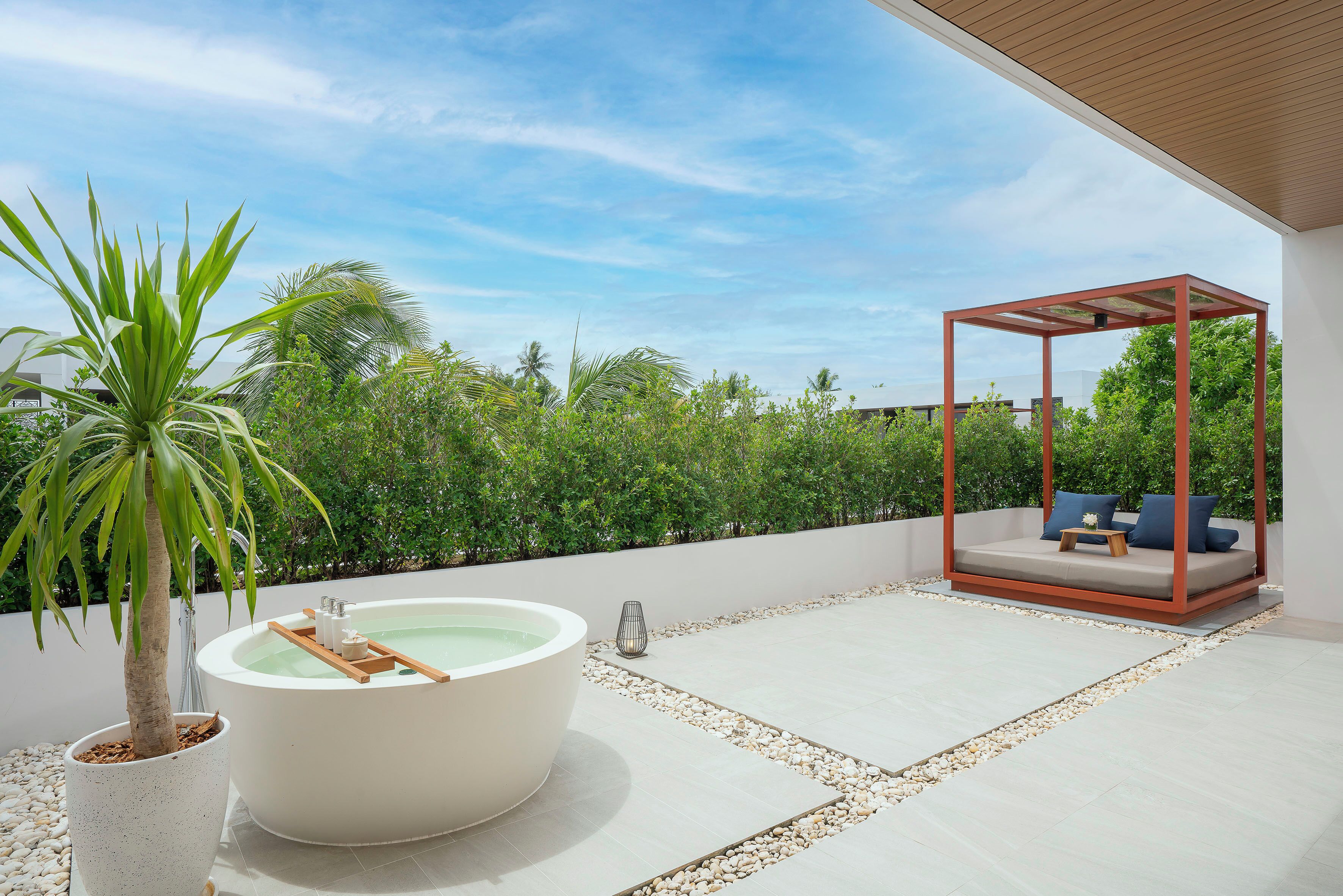 A spa area with a hot tub, a wooden swing chair, and a potted plant.