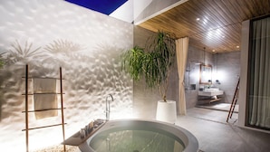 A modern bathroom with a large oval bathtub, a wooden ceiling, and a potted plant. - Melia Phuket Mai Khao (Mai Khao)