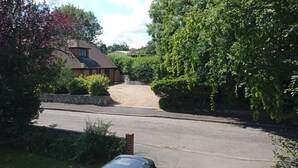 A residential street with a house, a driveway, and a parked car. - Oak End Lodge (Sevenoaks)