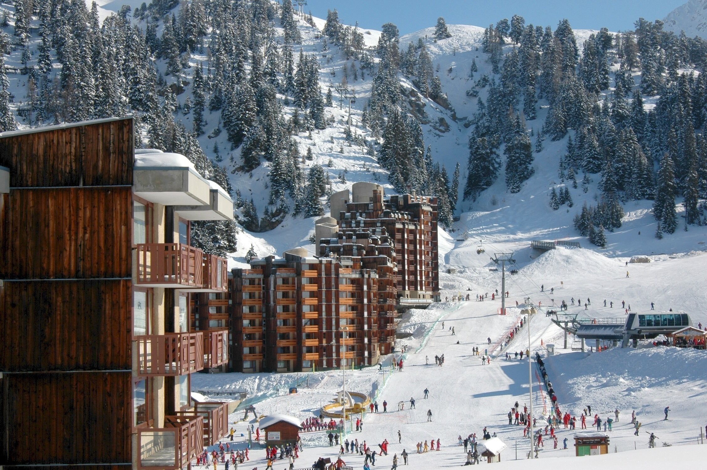 A ski resort with wooden buildings and a ski slope.