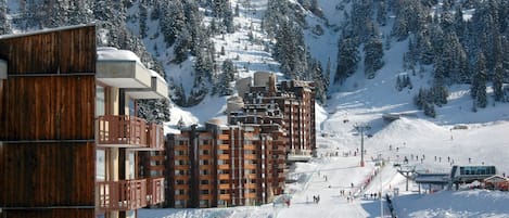A ski resort with wooden buildings and a ski slope.