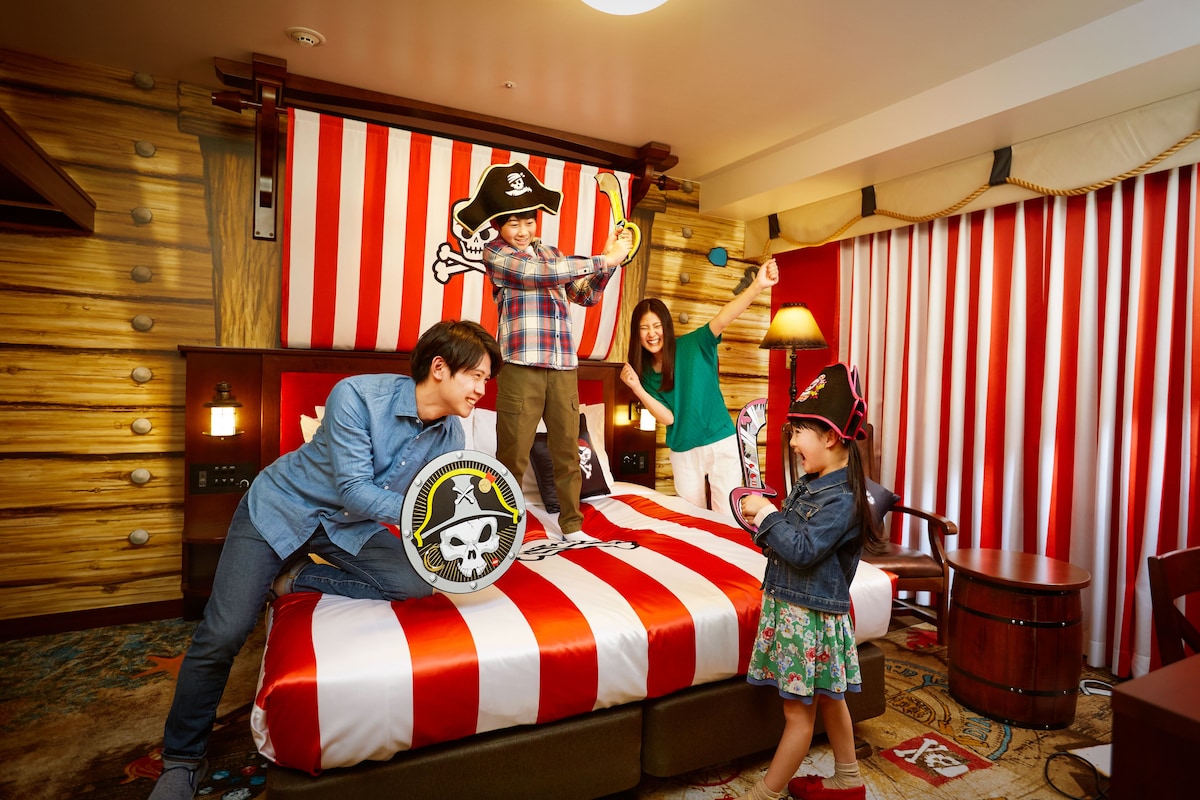 A room with a bed, wooden walls, and striped curtains.