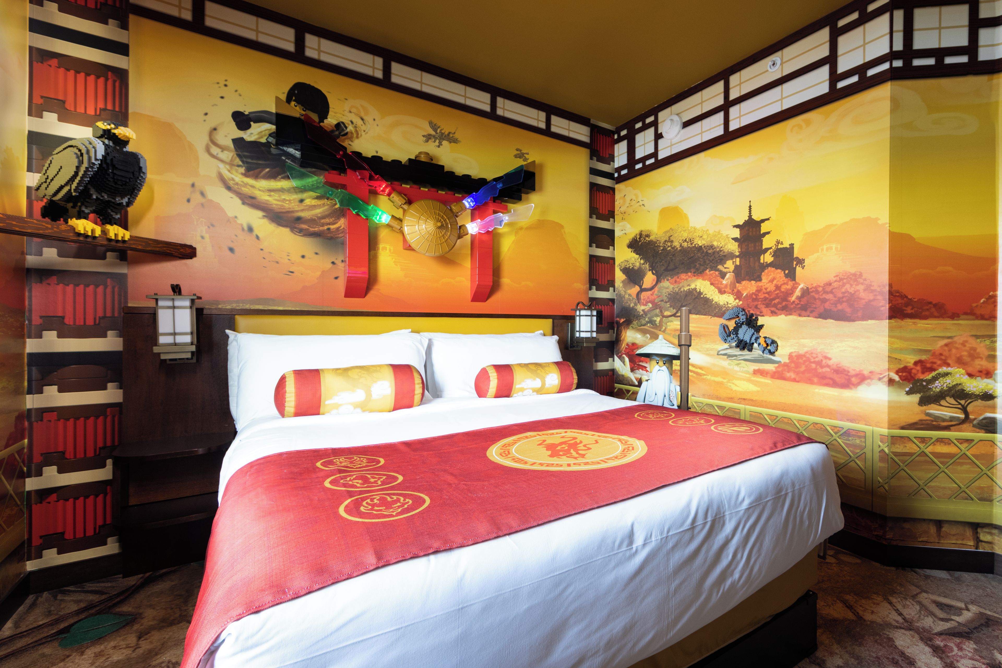 Una habitación de hotel con una cama grande, un mural en la pared y un diseño chino tradicional en el lateral.
