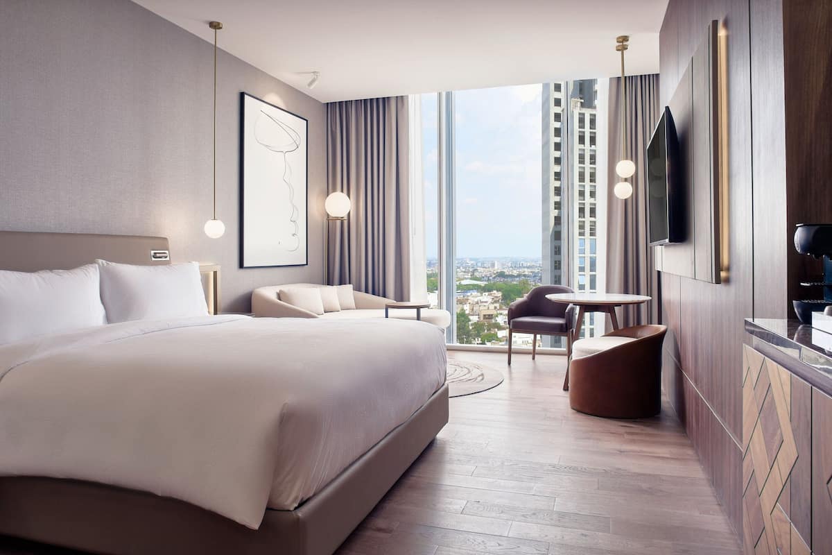 Een moderne hotelkamer met een groot bed, een bureau, een stoel en een televisie.