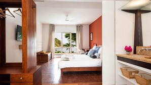 A bedroom with a large bed, wooden flooring, a wooden wardrobe, a desk, and a window with a view of greenery. - Tropic Lagoon loft, by the lagoon ! (Le François)