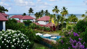 A resort with multiple buildings, a swimming pool, and a view of the ocean. - Tropic Lagoon loft, by the lagoon ! (Le François)