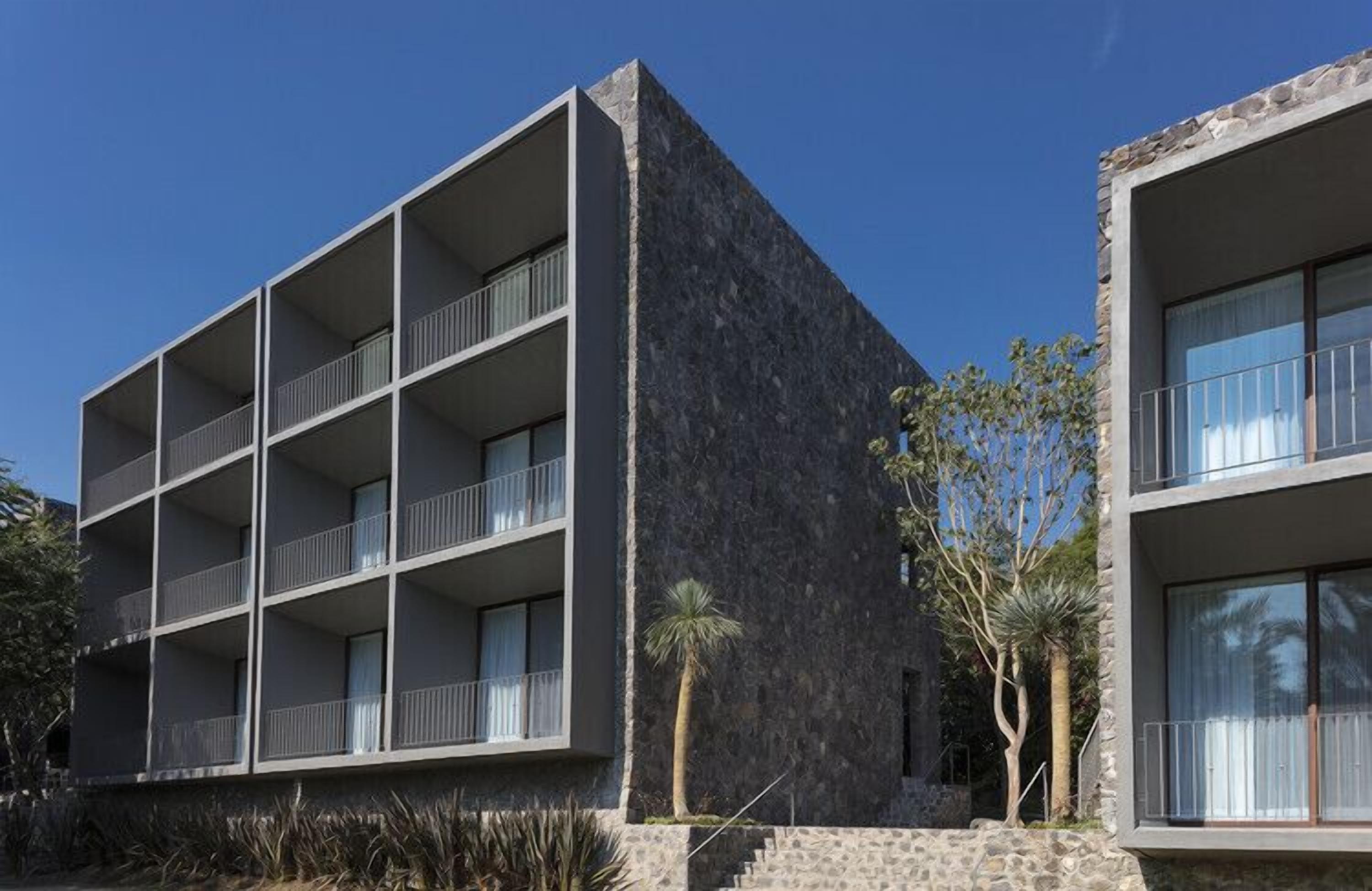 A modern building with multiple balconies and a stone facade.