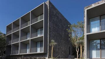 A modern building with multiple balconies and a stone facade.