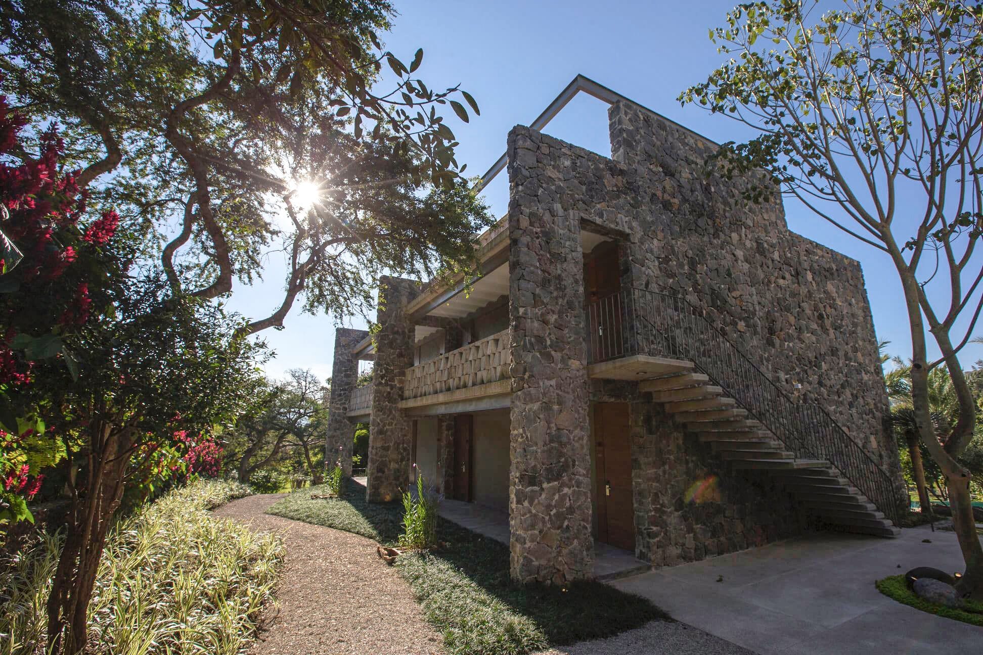 Un edificio de piedra con un balcón y una escalera que lleva a la entrada.