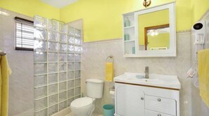 A bathroom with a glass shower enclosure, a toilet, a sink with a mirror, and a towel rack. - Fortune Estate (Rental car available)<br>Mount Fortune, Anguilla (East End)
