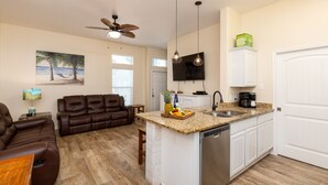 A modern kitchen with a built-in island, a dining area with a brown leather couch, and a living room with a brown leather sofa. - 4br/3Ba Oceanview from balcony!  Sleeps 12 w/ hot tub! (Corpus Christi)