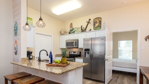 A kitchen with a central island, stainless steel appliances, and wooden bar stools. - 4br/3Ba Oceanview from balcony!  Sleeps 12 w/ hot tub! (Corpus Christi)