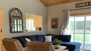 A living room with a large sectional sofa, two armchairs, a coffee table, and a painting. - Cozy Condo on the 4th Fairway of  Plumas Pines Golf Course (Blairsden Graeagle)