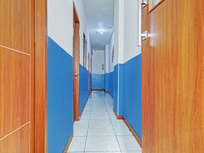 Un pasillo con puertas de madera y paredes azules.