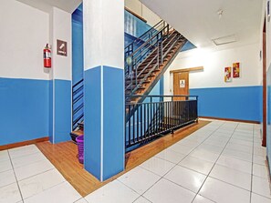 Una escalera con barandillas azules y escalones de madera que conduce a un rellano con una puerta marcada 'WATER'.
