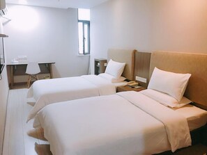 Una habitación de hotel con dos camas, un escritorio y una silla.