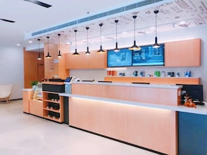 A modern reception area with a counter, digital display, and pendant lighting. - Hanting Hotel Shanghai Waigaoqiao Free Trade Zone (Shanghai)