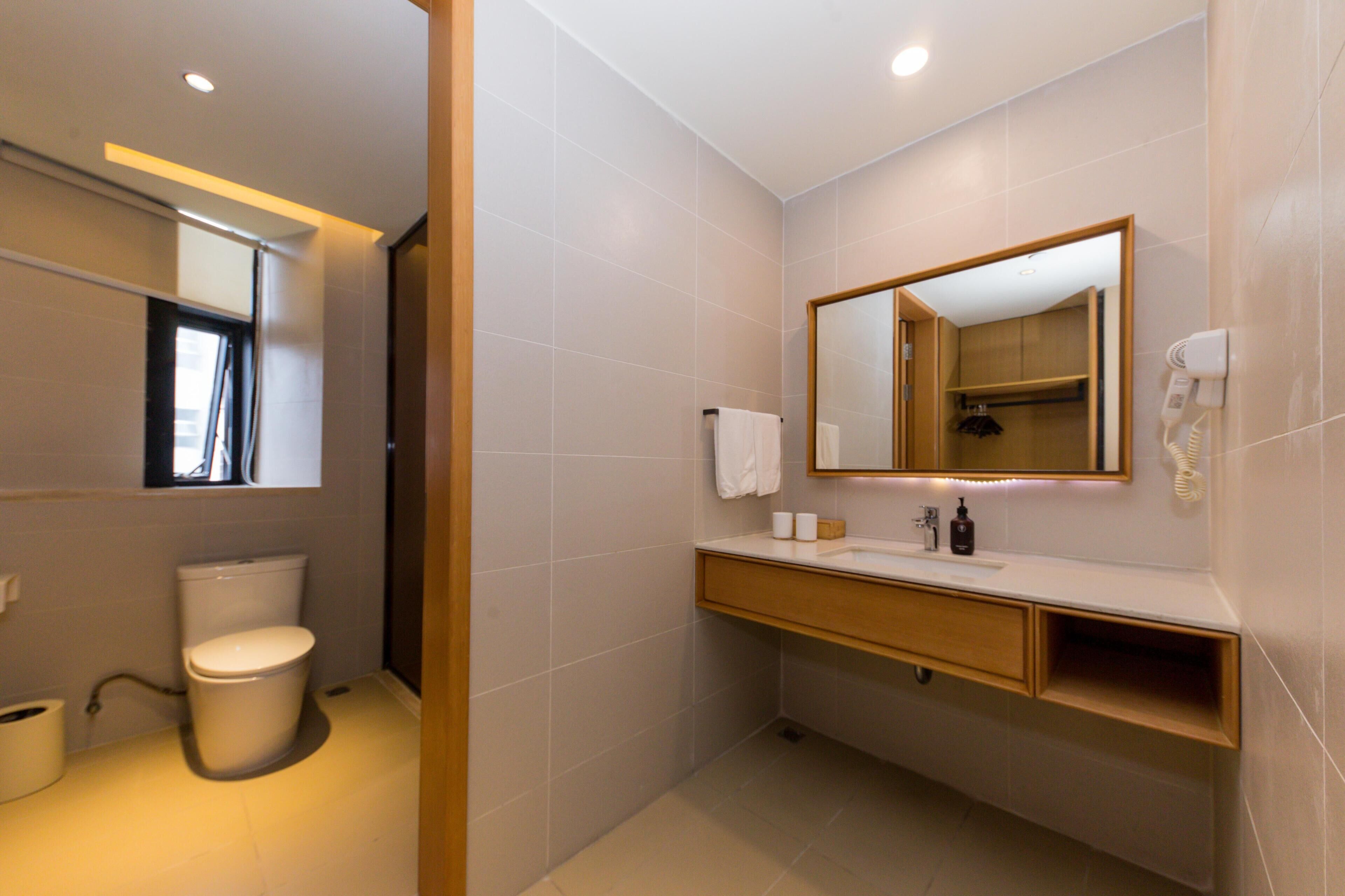 A modern bathroom with a toilet, sink, and mirror.