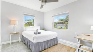 A bedroom with a bed, a desk, a lamp, and a ceiling fan. - Cozy 2 BR Home, walking distance to Crystal Beach/Park - Quaint Family Getaway! (Palm Harbor)