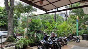 Un espace de stationnement couvert où plusieurs motos sont garées sous un auvent.